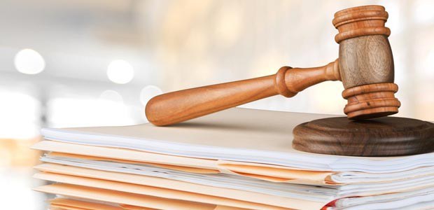 TRE-SC-martelo e processos Imagem de um martelo judicial sobre várias pastas de processos